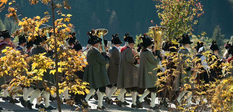 Zwischen zwei verfärbten Bäume sieht man Häuser eines Dorfes.