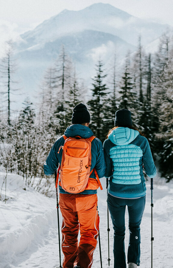 Ein Paar beim Winterwandern durch die winterliche Landschaft von Kals am Großglockner