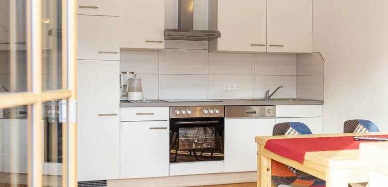 Küchenblock in einer Ferienwohnung mit Holzboden und einem Esstisch vom Balkon aus