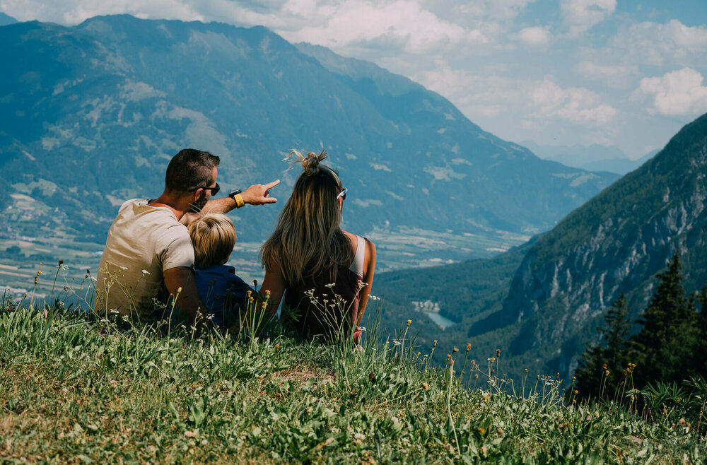 Pause mit Blick Richtung Talboden Una coppia si gode la vista dall'Hochstein che si estende a perdita d'occhio sulla valle.