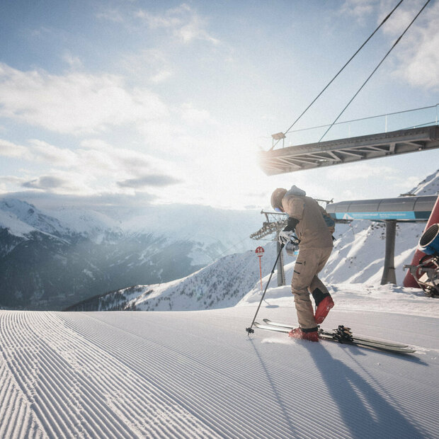 Ein Skifahrer steigt neben der Bergstation im Skigebiet "Großglockner Resort Kals-Matrei" in seine Ski.