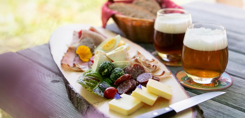 Brettljause mit Wurst, Käse und zwei Gläsern Bier im Gasthof Glocknerblick.