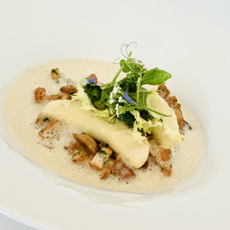 Teller mit Eierschwammerl Kartoffeltascherl Gericht.