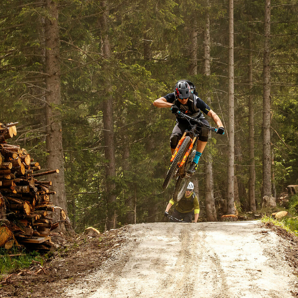 Biker hüpft über eine Bodenwelle. 