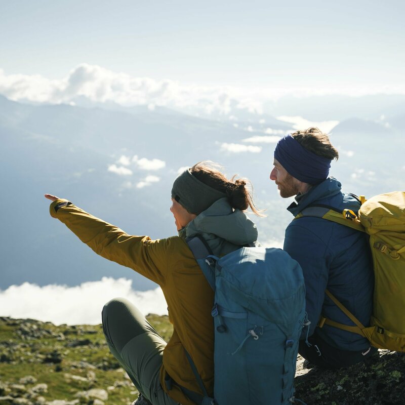 Ein Paar mit Rucksäcken genießt die Aussicht am Bösen Weibele. Die Frau zeigt dem Mann etwas in der Ferne.