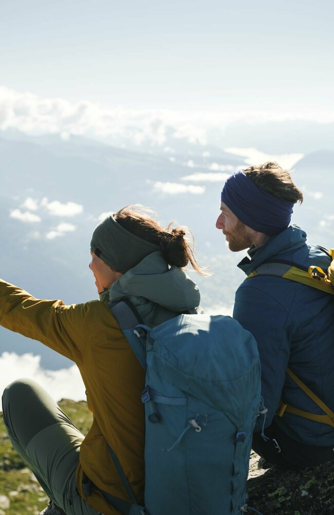 Ein Paar mit Rucksäcken genießt die Aussicht am Bösen Weibele. Die Frau zeigt dem Mann etwas in der Ferne.