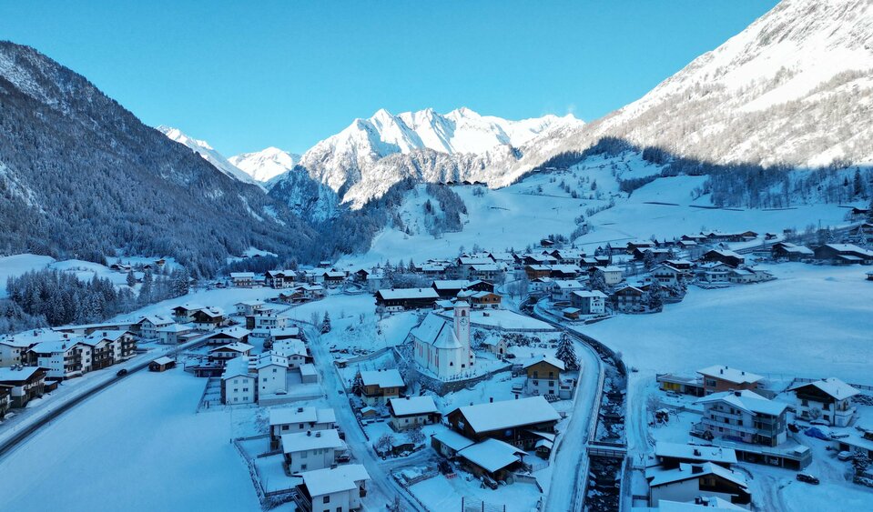 Winter in Prägraten am Großvenediger Blick auf die schneebedeckte Ortsgemeinde Prägraten am Großvenediger, mit der Kirche im Zentrum unter blauem Himmel.