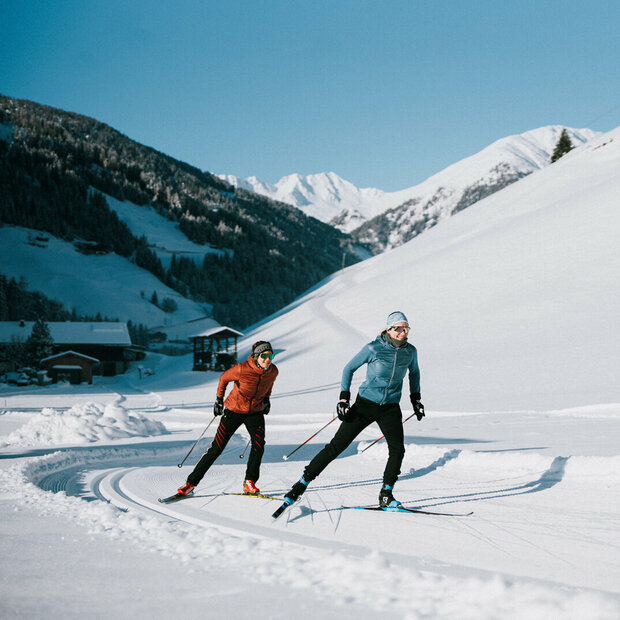 Zwei Langläufer:innen bei perfekten Loipen- und Wetterbedingungen in Innervillgraten.