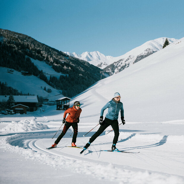 Ob Skating oder Klassisch: Auf Osttirols Loipen ist für jede:n etwas dabei. Zwei Langläufer:innen bei perfekten Loipen- und Wetterbedingungen in Innervillgraten.