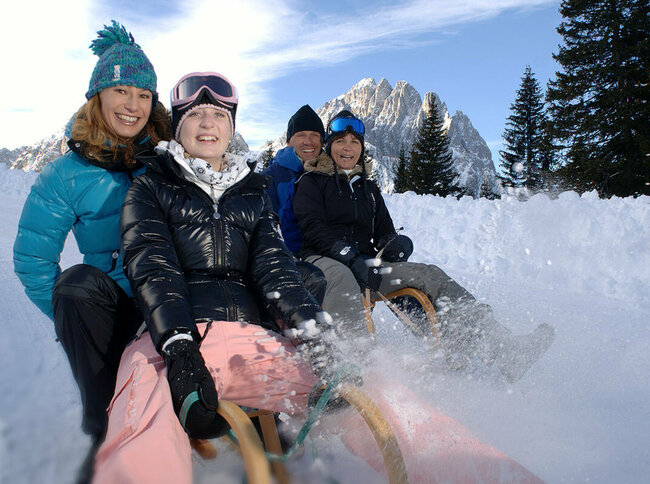 Rodeln Rodelspaß zu viert bei sonnigem Wetter in Osttirol.