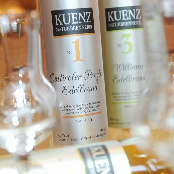 Vor zwei Flaschen Osttiroler Pregler liegt eine Flasche und davor ist ein leeres Schnapsglas anschaulich positioniert.