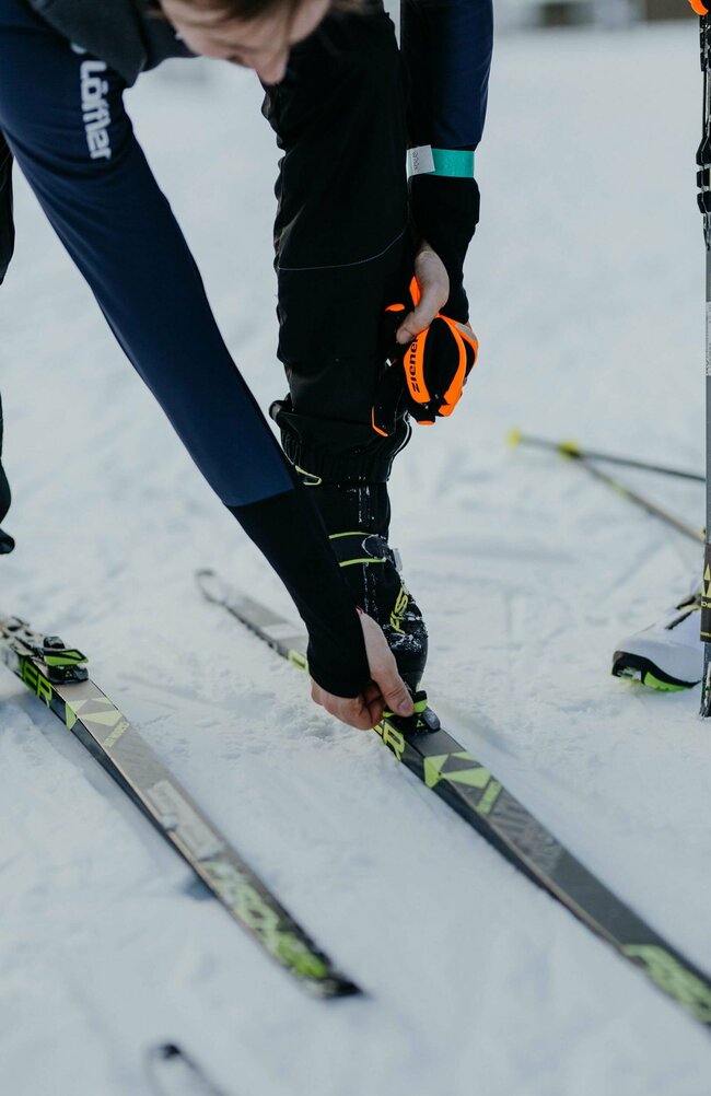 Langläufer Obertilliach Nahaufnahme eines Langläufers beim Justieren seiner Langlaufskier in Obertilliach.