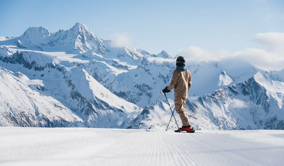 Ein Skifahrer auf der weißen Piste im Großglocknerresort Kals-Matrei mit der imposanten Bergwelt Osttirols im Hintergrund.
