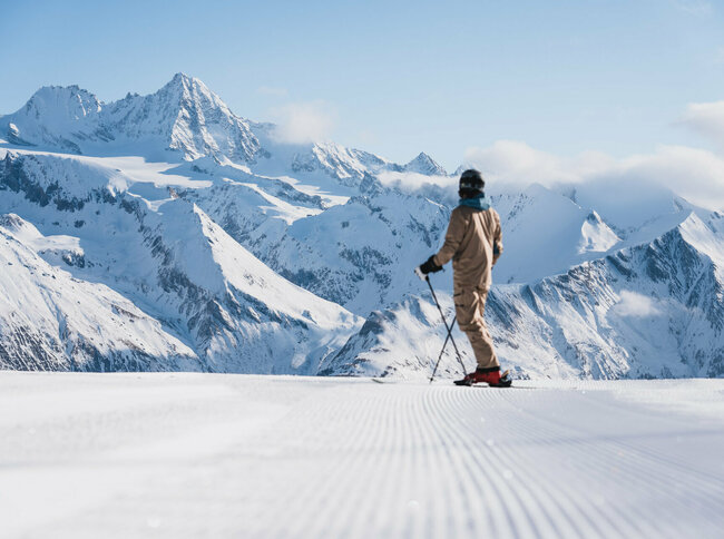 Ein Skifahrer auf der weißen Piste im Großglocknerresort Kals-Matrei mit der imposanten Bergwelt Osttirols im Hintergrund.