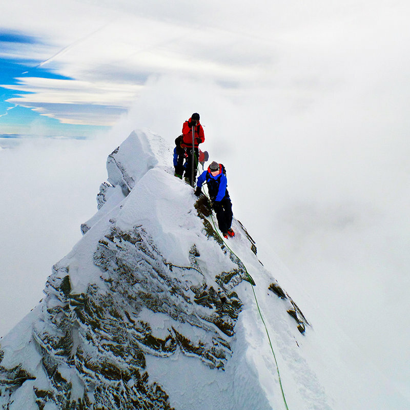 Zwei Bergsteiger:innen erklimmen den Gipfle des Kleinglockner