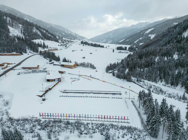 Drohnenaufnahme des Langlauf- und Biathlonzentrums Obertilliach aus westlicher Richtung im Winter.