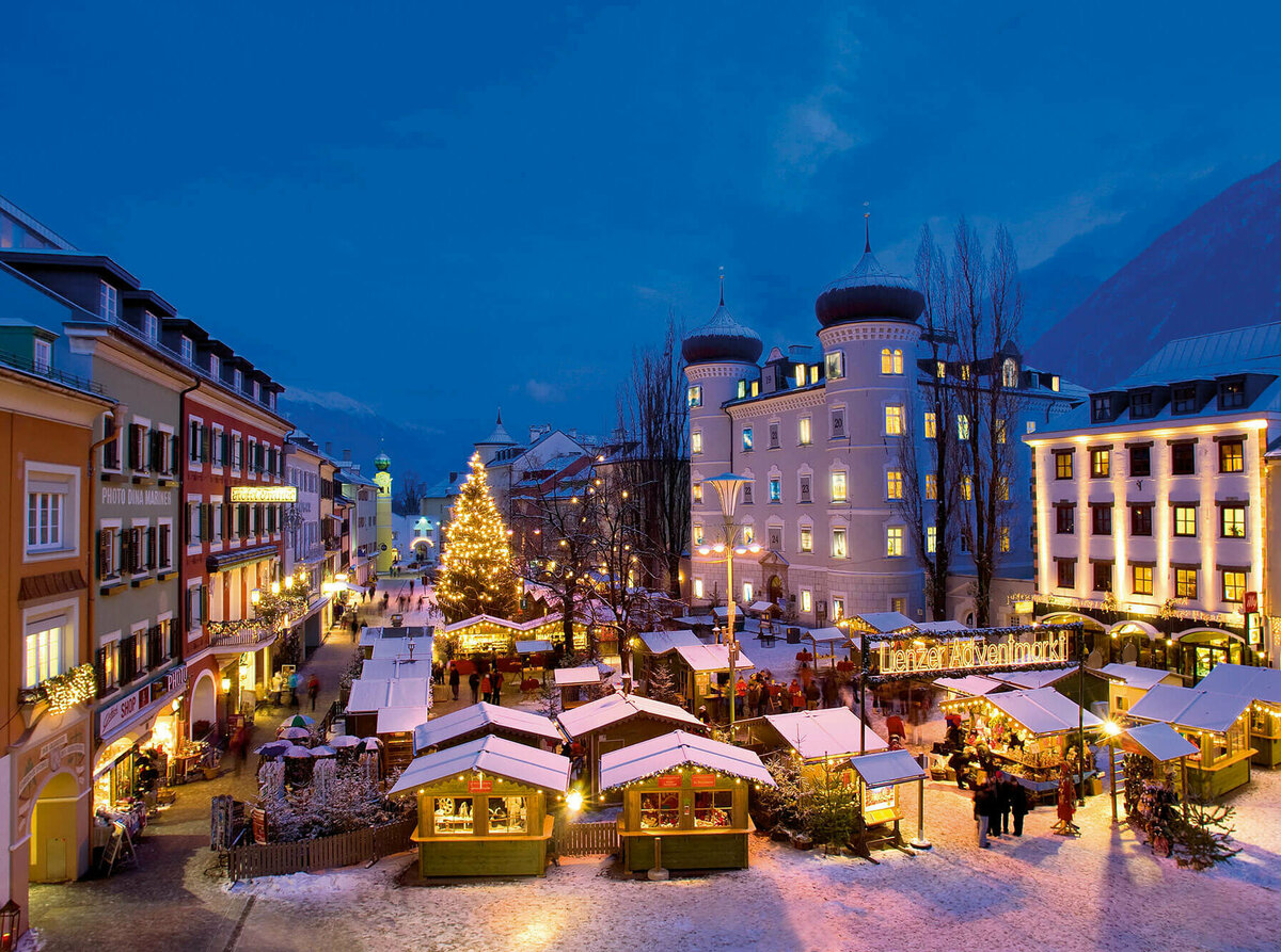 Adventmarkt Lienz Beleuchteter Adventmarkt am Hauptplatz in Lienz in frühabendlicher Stimmung.
