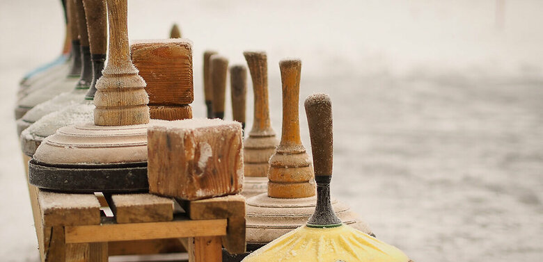 Eine hölzerne Bank voll Equipment zum Eisstockschießen.