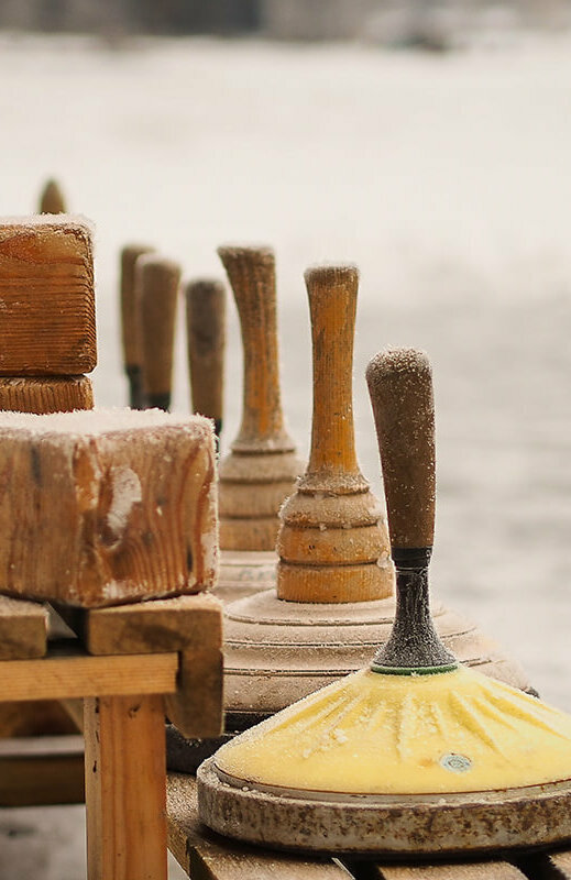 Eisstock Eine hölzerne Bank voll Equipment zum Eisstockschießen.