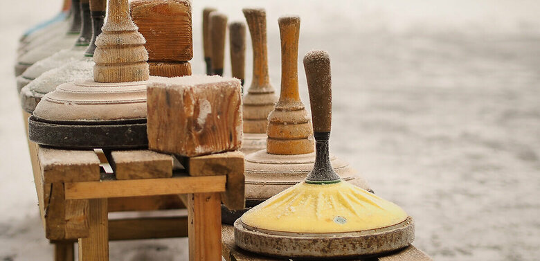 Eine hölzerne Bank voll Equipment zum Eisstockschießen.