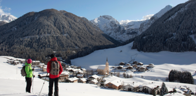 Ein Paar blickt vom Wiesenweg in Kartitsch auf das Dorf