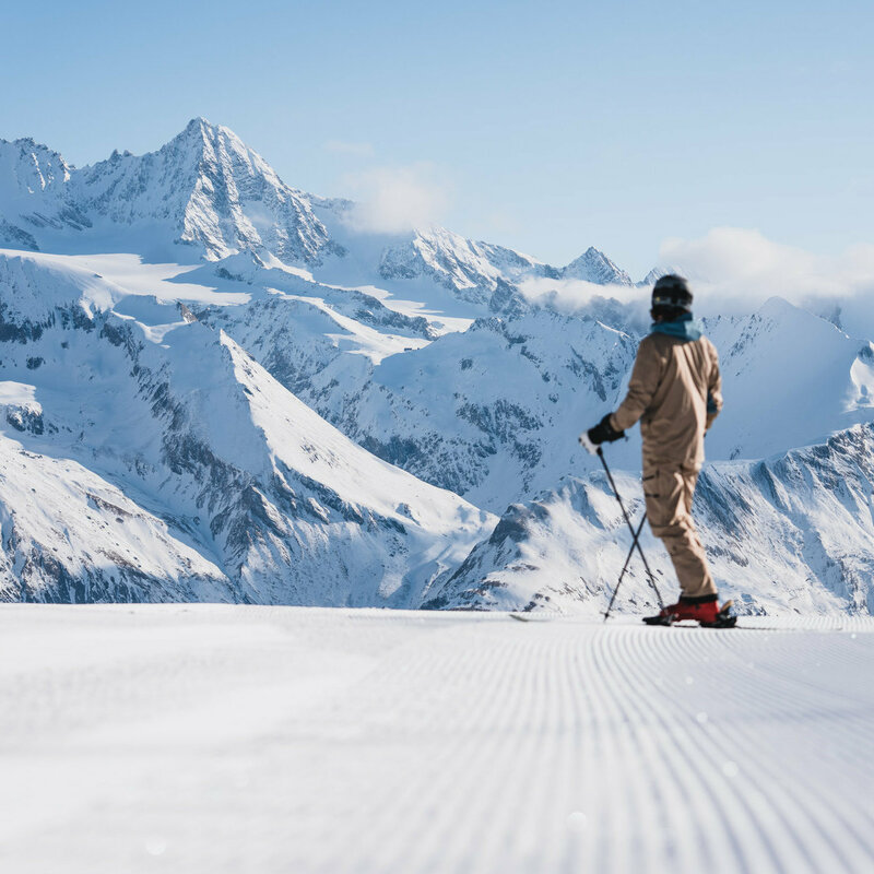 Ein Skifahrer auf der weißen Piste im Großglocknerresort Kals-Matrei mit der imposanten Bergwelt Osttirols im Hintergrund.