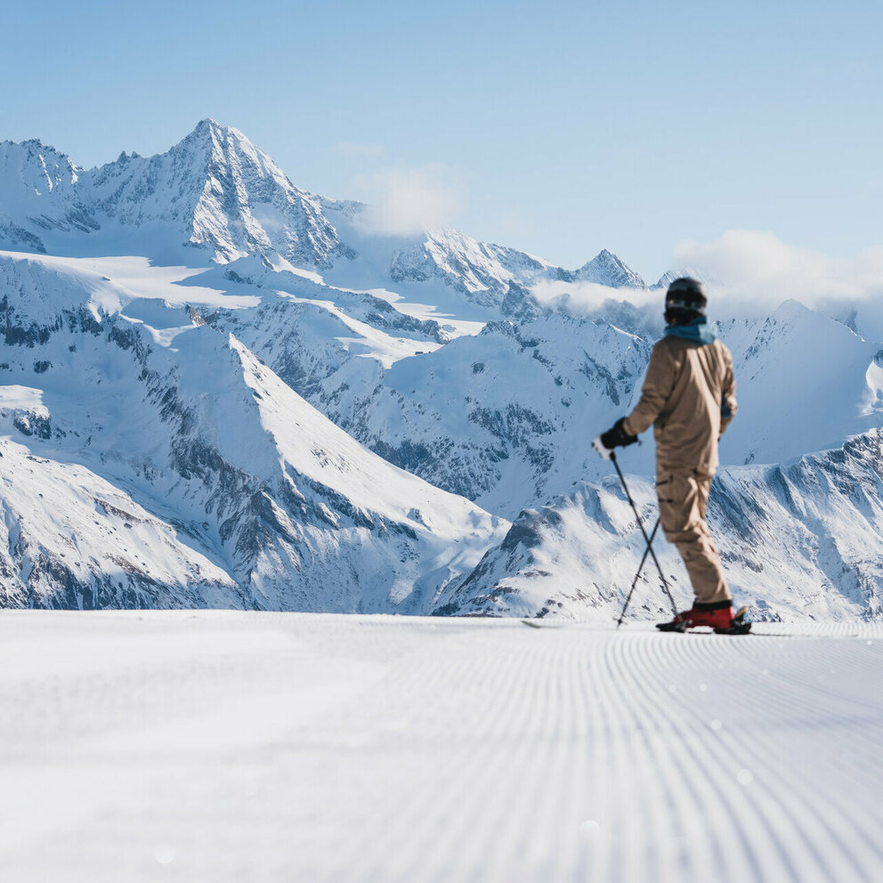 Ein Skifahrer auf der weißen Piste im Großglocknerresort Kals-Matrei mit der imposanten Bergwelt Osttirols im Hintergrund.