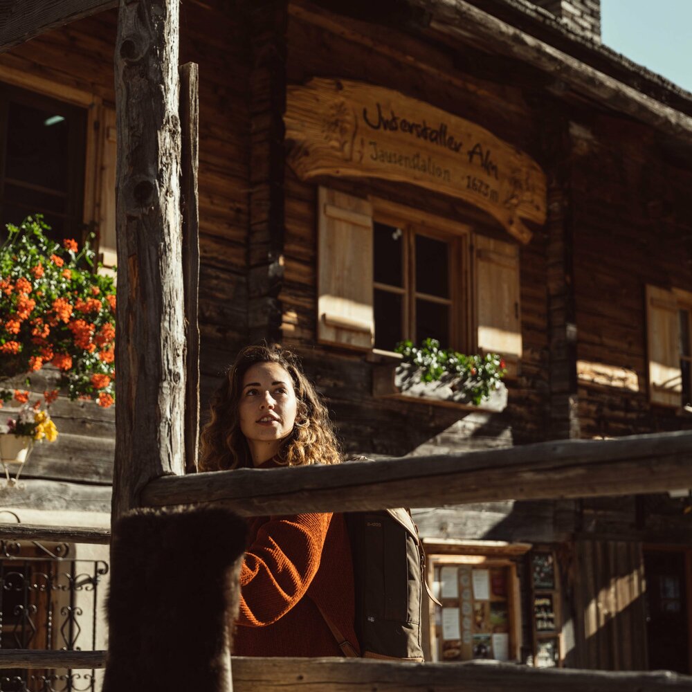 Oberstalleralm Villgratental im Herbst Eine Frau steht vor einer Hütte der Oberstalleralm im herbstlichen Villgratental.