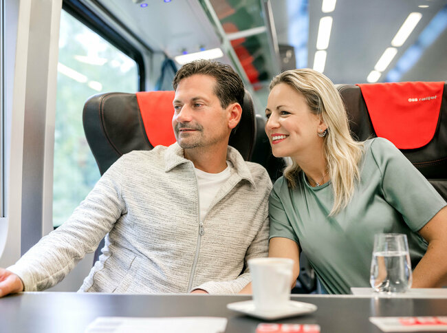 Pärchen reist mit dem ÖBB Railjet.