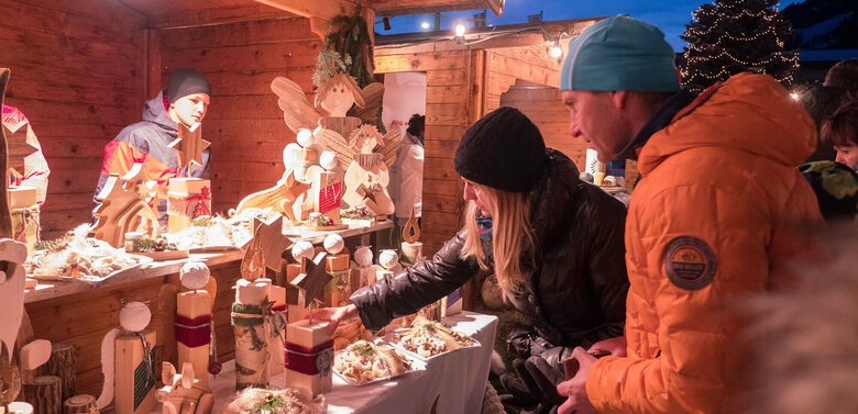 Paar sucht Weihnachtsdekorationen bei einem Stand am Adventmarkt beim Brückenwirt in Heinfels