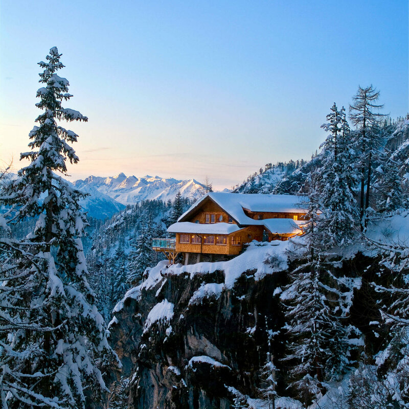 Die Dolomitenhütte auf einem Felsen in den Lienzer Dolomiten im Winter in der Dämmerung.