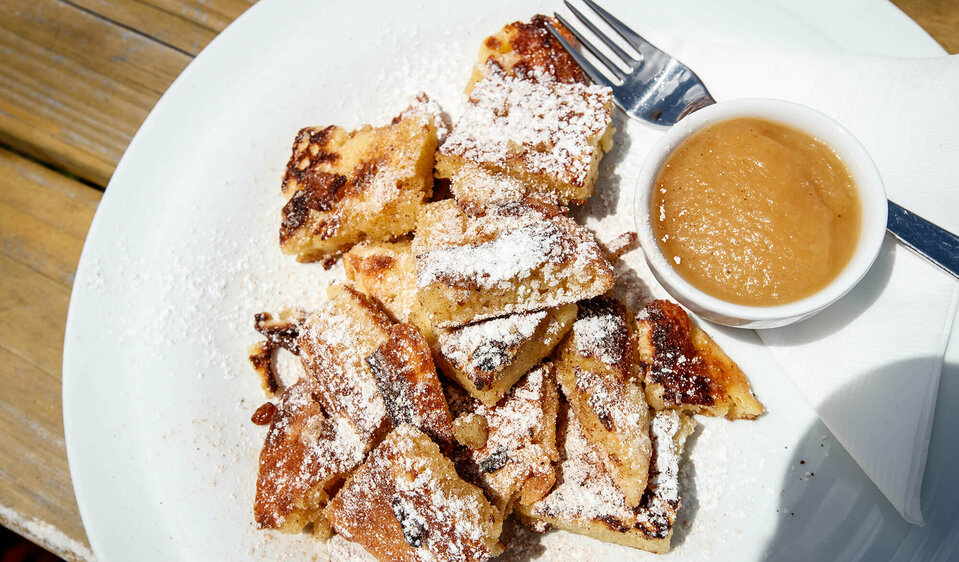 Kaiserschmarren Kaiserschmarren mit Apfelmus in einem separaten Schüsselchen auf einem weißen Teller.