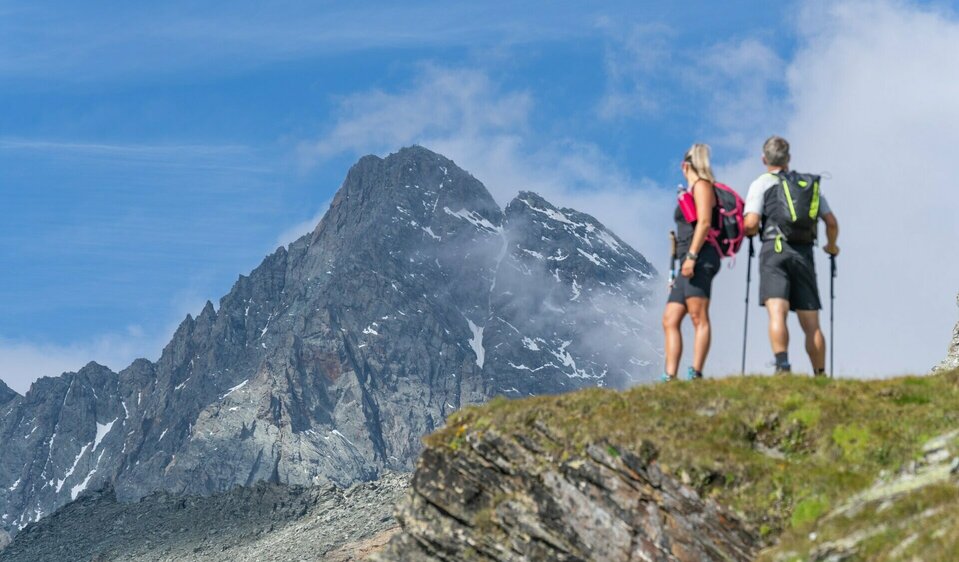 Zwei Wanderer blicken auf den Großglockner auf Etappe 3 der Glocknerkrone beim alpinen Weitwandern.