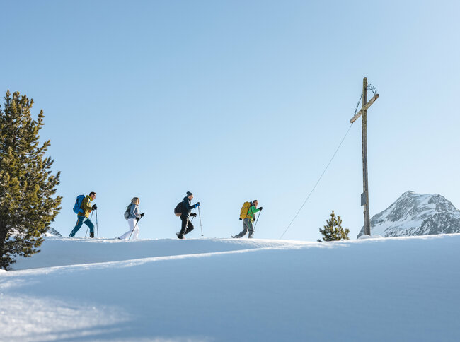 Eine Gruppe beim Schneeschuhwandern bei sonnigem Wetter im Nationalpark Hohe Tauern in Osttirol