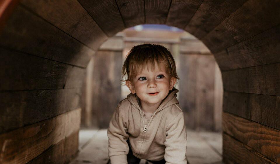 Kind krabbelt durch einen Tunnel
