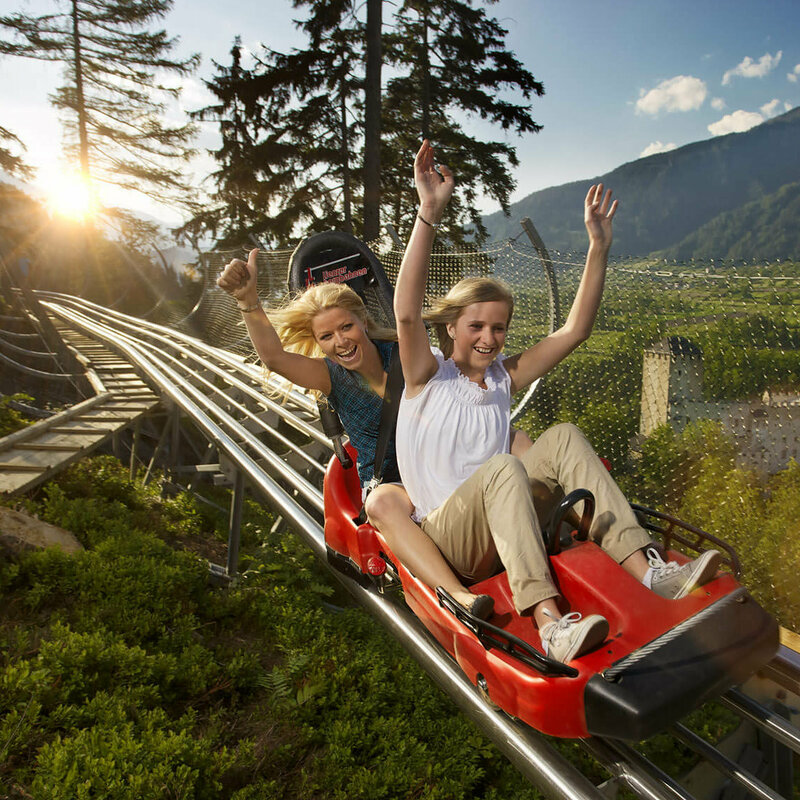 Das Bild zeigt 2 Frauen auf der Sommerrodelbahn "Osttirodler" in Lienz