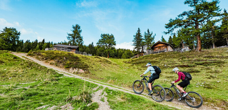 Zwei Biker sind unterwegs am Ederplan in Osttirol und fahren auf einem Weg bergauf.