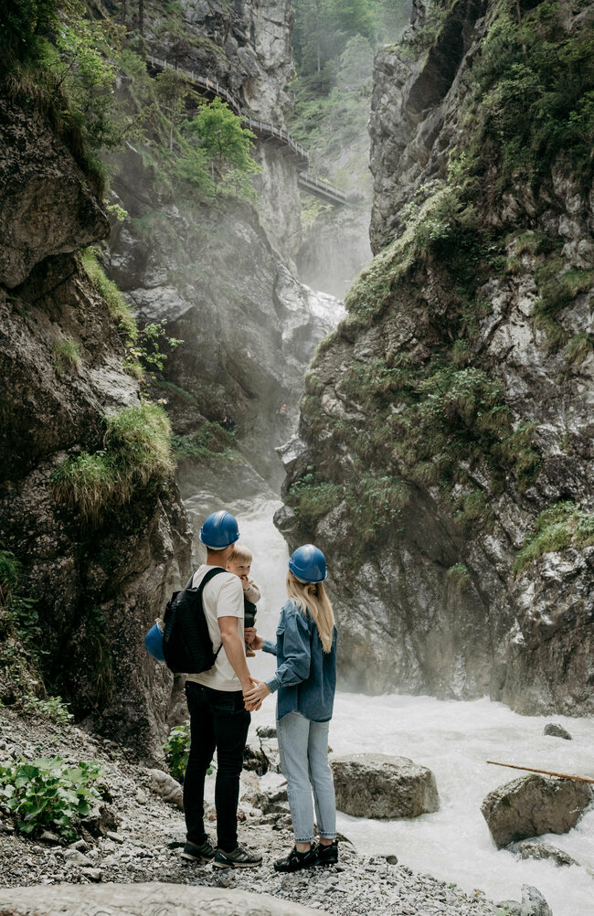 Ein Pärchen mit kleinem Kind auf dem Arm am Wasserschaupfad in der Galitzenklamm.