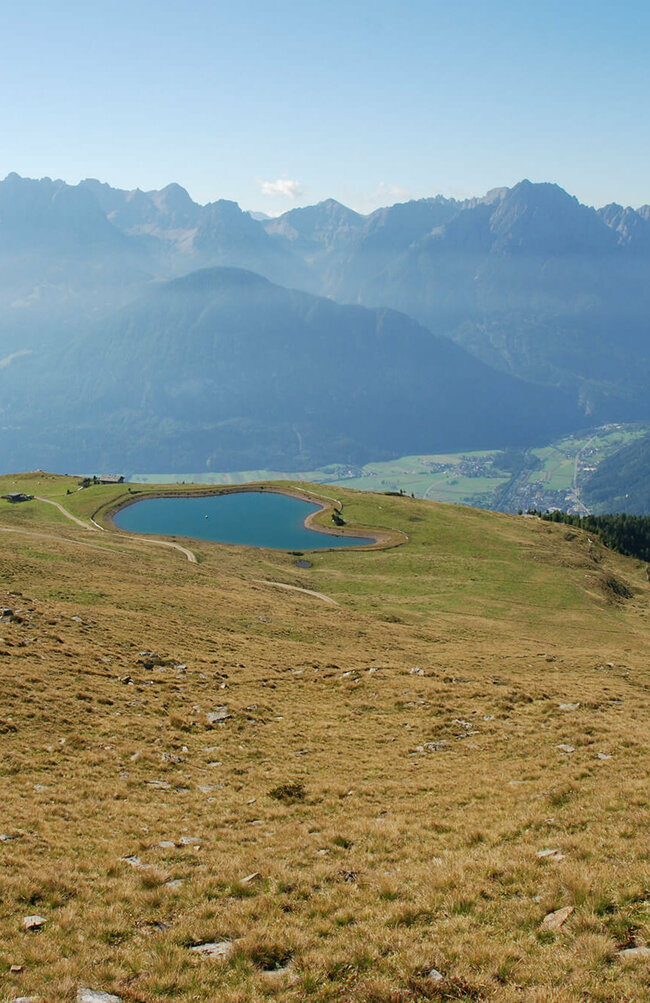 Speicherteich am Zettersfeld mit Blick auf den Lienzer Talboden und umliegende Berge der Lienzer Dolomiten