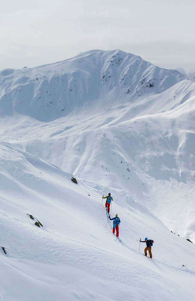 Skitourengeher:innen auf der Herz-Ass in einer verschneiten Berglandschaft im Villgratental