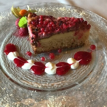 Ein Stück Ribiselkuchen auf einem Glasteller.