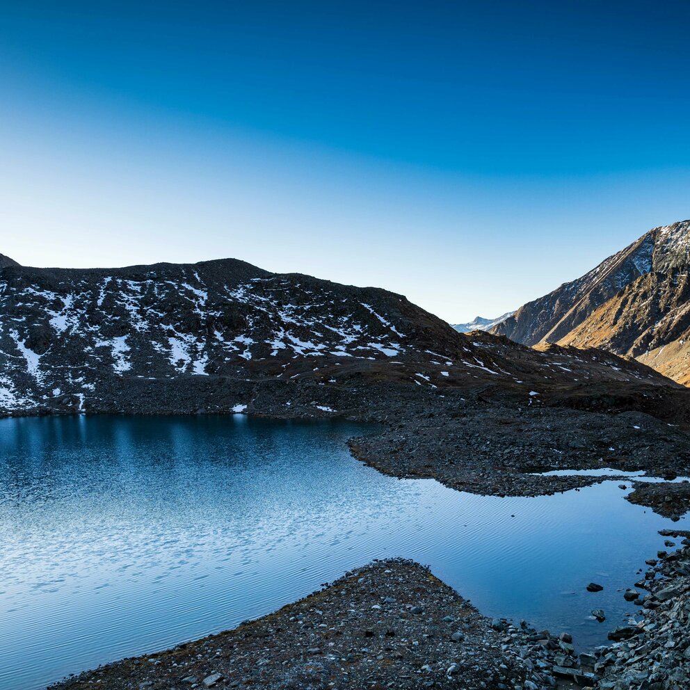 Der klare Eissee im Timmeltal bei Kaiserwetter. Letzte Schneereste liegen auf den umliegenden Bergen.