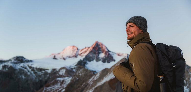 Figerhorn Wanderer nach Sonnenuntergang am Figerhorn mit dem schneebedeckten Großglockner im Hintergrund.