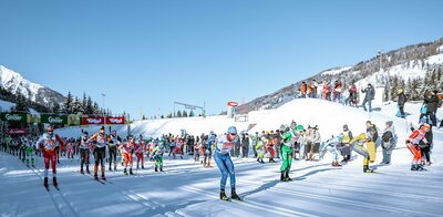 Start beim Dolomitenlauf in Obertilliach - zahlreiche Teilnehmer tummeln sich in den klassischen Spuren der Loipe bei herrlichem Winterwetter.