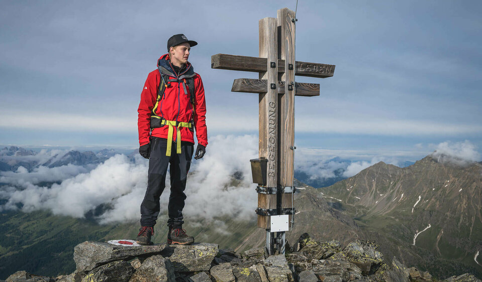 Ein Wanderer auf dem Gipfel des Regenstein in Außervillgraten