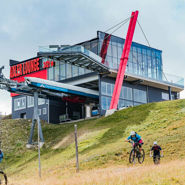 Zwei talwärts fahrende Mountainbiker unterhalb der Bergstation der Gondelbahn im Großglockner Resort Kals-Matrei