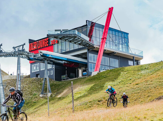 Zwei talwärts fahrende Mountainbiker unterhalb der Bergstation der Gondelbahn im Großglockner Resort Kals-Matrei