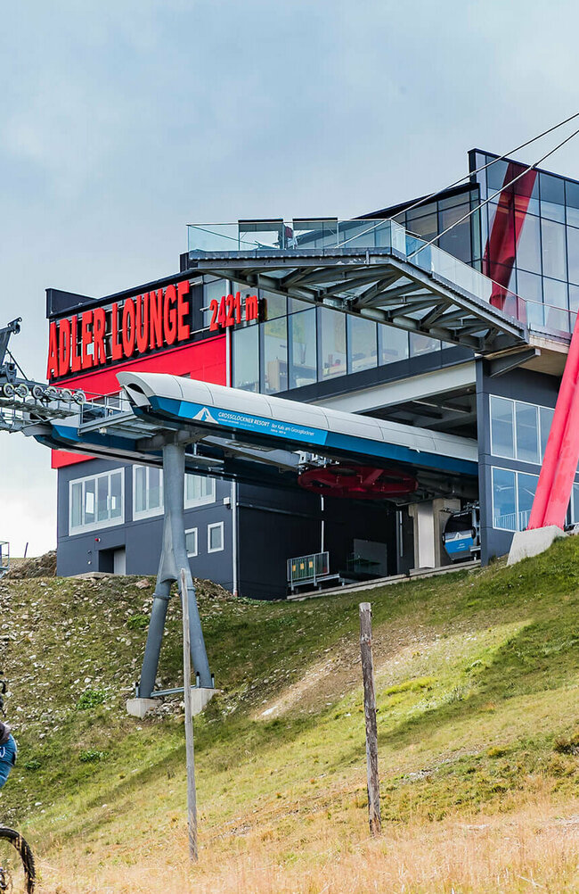 GG Resort Kals Matrei Adler Lounge Zwei talwärts fahrende Mountainbiker unterhalb der Bergstation der Gondelbahn im Großglockner Resort Kals-Matrei