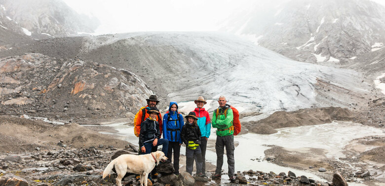 Familie mit Hund bei einer Rangertour im Nationalpark Hohe Tauern bei schlechtem Wetter.