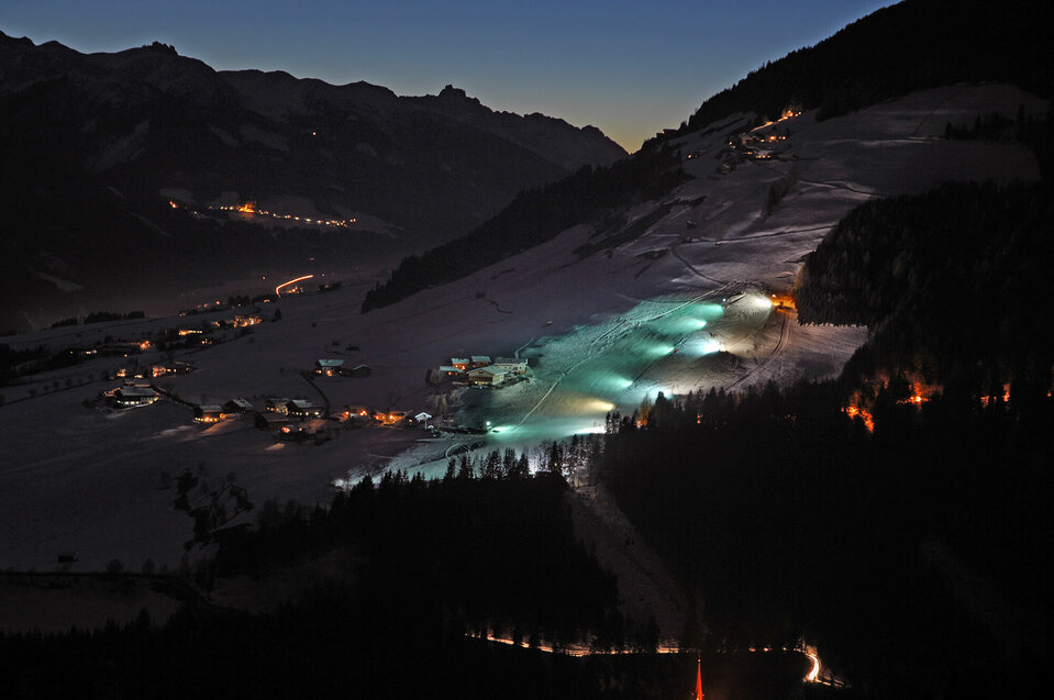 Blick auf den beleuchteten Lanalift bei Nacht in Anras.